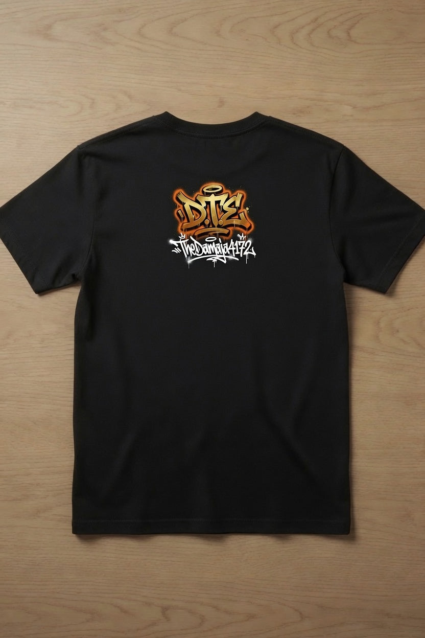 A black short-sleeve t-shirt laid flat on a light brown wooden surface, featuring a stylized orange and white graphic print on the back. 